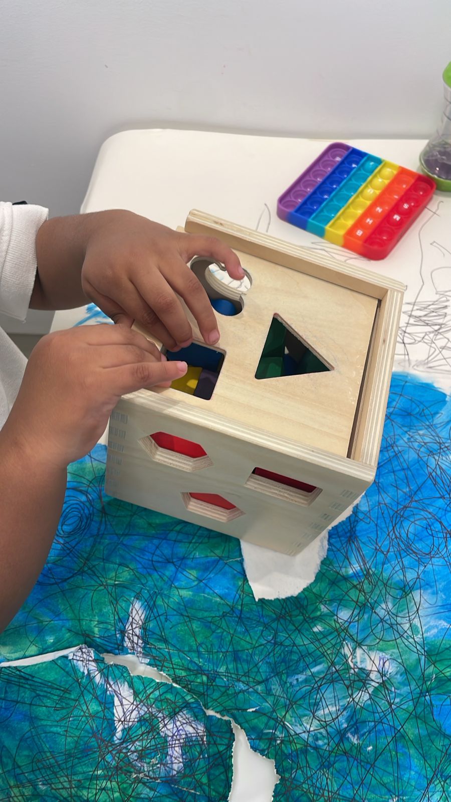 Niño encajando figuras en un clasificador de madera